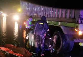 Pasca kejadian, petugas berusaha mengevakuasi korban yang terlindas ban belakang truk.