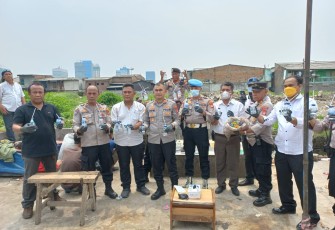 Polisi saat menunjukan barang bukti sitaan hasil penggerebekan.