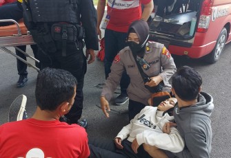Polisi saat membantu salah seorang sporter