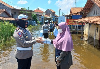 Personel Polres Pekalongan Kota membagikan nasi kotak kepada masyarakat terdampak banjir di Desa Karangjompo