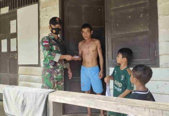 Anggota Satgas Yonif 144/JY Bagikan Masker ke Rumah Warga 