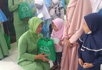 Ketua Persit KCK Ranting 5 Koramil 04/Sangasanga saat memberikan santunan