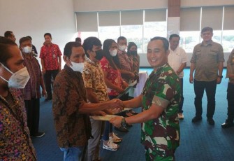 Dandim 1310/Bitung Letkol Arm Yoki Efriandi saat menyerahkan sertifikat kepada masyarakat