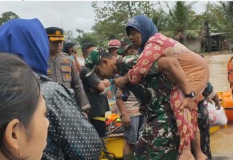Dandim 0806/Trenggalek Letkol Kav Peddy Adi Prasetyo saat menggendong warga