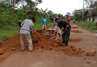 Sertu Ismanti gotong royong timbun jalan berlubang bersama warga binaan