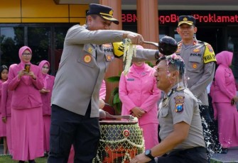 Kapolres Blitar Kota AKBP Argowiyono saat menyiram air bunga anggotanya naik pangkat