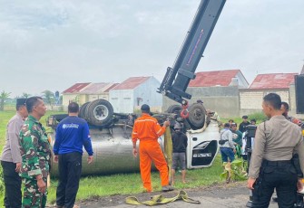 Upaya evakuasi truk tangki bermuatan air yang terperosok hingga terguling di areal persawahan di di Desa Karangmojo, Kecamatan Tasikmadu, Kabupaten Karanganyar, Senin (26/12/2022).