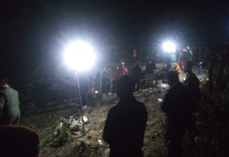 Petugas saat Kumpulkan Serpihan Pesawat yang Jatuh di Desa Nginggil, Senin (18/7/2022) malam.