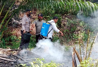 Polisi dan warga saat padamkan api kebakaran lahan