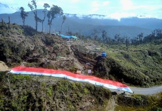 Satgas 330 dan Masyarakat Bentangkan Bendera Merah Putih Raksasa