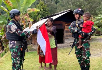 Masyarakat Yambi saat Kibarkan Bendera Merah Putih Bersama Satgas Yonif RK 115/ML