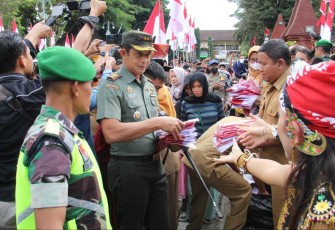 Dandim 0806/Trenggalek Letkol Kav Peddy Adi Prasetyo saat membagikan bendera merah putih ke masyarakat, Senin (31/7)