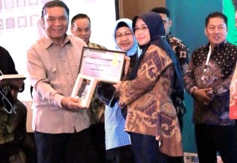 Pj Gubernur Banten Al Muktabar saat menyerahkan penghargaan kepada Kepala DPMPTSP Kota Cilegon Hayati Nufus, Kamis (19/10)