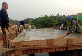 Serda Supriadi saat mengecor jembatan