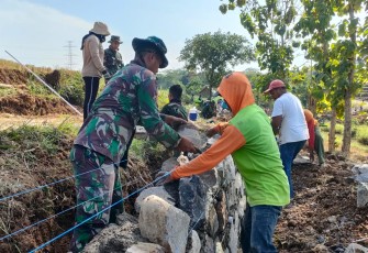 "Satgas TMMD Reg ke-117 Mojogedang sedang memasang talud pembats kanan-kiri jalan bersama warga"