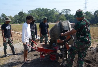 "Warga bersama Satgas TMMD bahu membahu dalam pekerjaan TMMD"