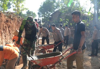"Anggota Satgas TMMD Reg desa Gentungan tampak sedang mendorong arco/angkong"