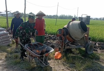 Babinsa Kodim Madiun saat Bantu Masyarakat Bangun Saluran Irigasi