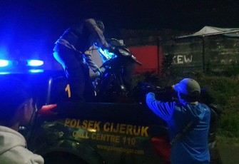 Polisi saat evakuasi motor yang ditinggalkan, diduga milik pelaku.