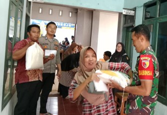Babinsa Koramil 0801/11 Donorojo saat Dampingi Penyaluran Beras