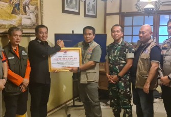 Deputi Bidang Penanganan Darurat BNPB Mayjen TNI Fajar Setyawan, S.I.P., secara simbolis menyerahkan bantuan Dana Siap Pakai (DSP) kepada Plt. Bupati Karawang Aep Syapuloh dalam kunjungan ke lokasi pengungsian banjir Kabupaten Karawang, Minggu (7/1). 