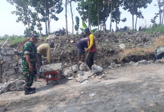 Babinsa Desa Sukisari Laksanakan Karya Bakti Pembuatan Talud Jalan 