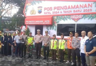 Babinsa Koramil 0833/01 Klojen Serka Dayu foto bersama stakeholder di Pos Pam Pelayanan Kayutangan, Selasa (31/12)