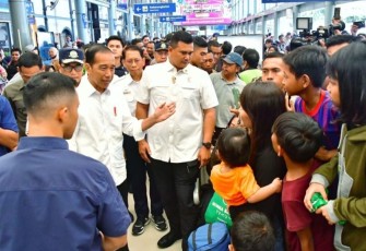 Presiden Joko Widodo saat berbincang dengan pemudik di stasiun Pasar Senen Jakarta, Senin (8/4)