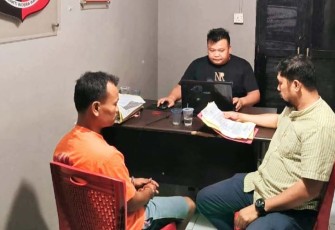Tersangka diborgol (kiri) saat diperiksa penyidik
