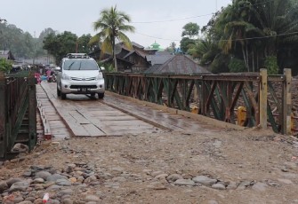 Kendaraan roda empat melintas di jembatan baily dari arah Provinsi Tapanuli Tengah menuju Tapanuli Selatan via Desa Garoga, Batang Toru pada Minggu (14/12)