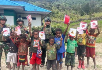 Anak-anak terseyum gembira mendapatkan buku dan alat tulis