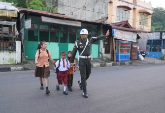 Anggota Denpom 1/2 Sibolga menyeberangkan anak sekolah