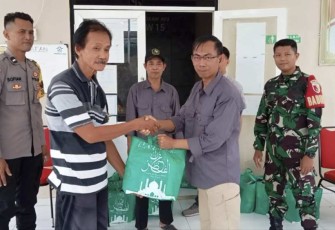 Michael Markus Ketua RW 15 Kelurahan Medokan Ayu menyerahkan paket sembako, Kamis (27/3)