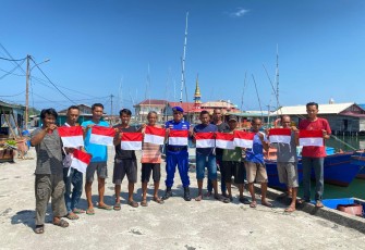 Nelayan Perbatasan saat terima bendera merah putih dari Satpolairud Polres Natuna.
