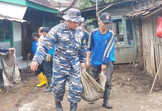 Prajurit TNI AL saat Bantu Masyarakat Terdampak Banjir di Situbondo