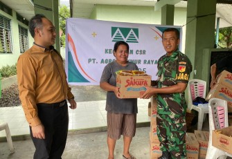 Personil Kodim 1310/Bitung bersama pihak Manajemen PT. AMR saat membagikan sembako kepada masyarakat