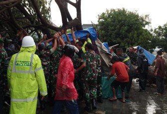 Prajurit TNI dari Kodim 0727Karanganyar mengevakuasi korban tertimpa pohon tumbang, di kawasan plaza alun-alun Karanganyar, Jumat (2132025) sore.