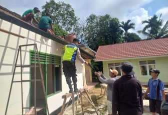 Bhabinkamtibmas Polsek Belitang III Laksanakan Gotong Royong Renovasi Aula Balai Desa