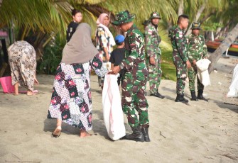 Bersihkan pantai bersama warga