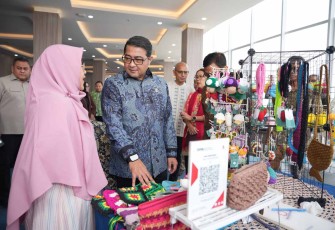 Menteri Ekonomi Kreatif/Kepala Badan Ekonomi Kreatif (Ekraf), Teuku Riefky Harsya (kanan), berbincang dengan salah satu pemilik tenant seusai membuka Re:Rasa International Poster Biennale 2026 di Universitas Paramadina, Jakarta, Jumat (31/07/2026).