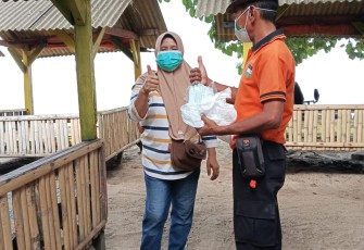Personil BPBD Kabupaten Serang membagikan masker kepada masyarakat sebagai upaya perlindungan dari paparan abu vulkanik Gunung Anak Krakatau, Minggu (6/9). (Sumber: BPBD Kabupaten Serang)