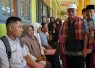 Pepi Mulyasari (berbaju abu-abu, kanan) sedang mendaftarkan putranya ke SLBN 1 Padang